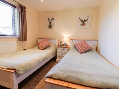 Bempton的住宿－Deer Lodge，带窗户的客房内设有两张单人床。
