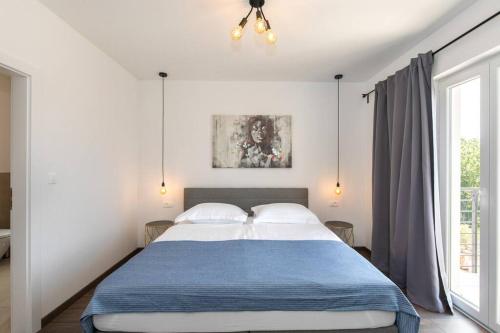 ein Schlafzimmer mit einem großen Bett und einem Fenster in der Unterkunft Villa Albina in Skrbčići
