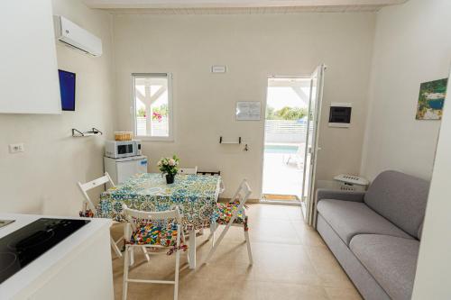 a kitchen and living room with a table and a couch at Perladelmare in Avola