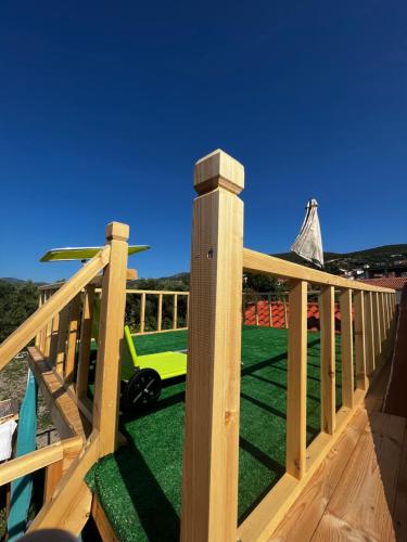 une terrasse en bois avec une voiture jouets sur l'herbe dans l'établissement Holiday Oasis with private patio and Hammam-style bath in Chora-Pithagoreo, Samos Island, à Chóra