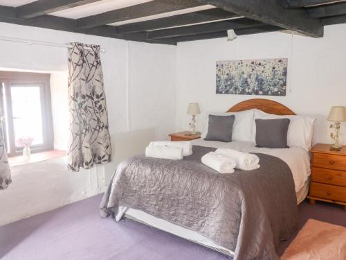a bedroom with a large bed with towels on it at Lilac Cottage in Paignton