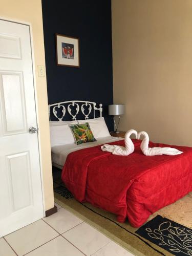 dos cisnes sentados en una cama en un dormitorio en The Chancellor Hotel, en Puerto España