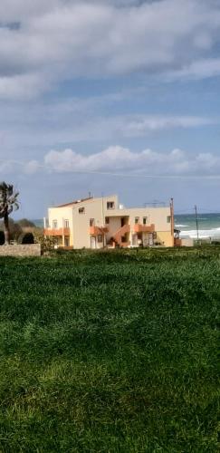a house on the beach next to a field of grass at MARIA cozy apartments in Pigianos Kampos