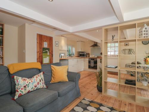 a living room with a couch and a kitchen at Nuthatch in Honiton