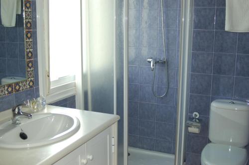 a bathroom with a toilet and a sink and a shower at Apartamentos VIDA Sanxenxo in Sanxenxo