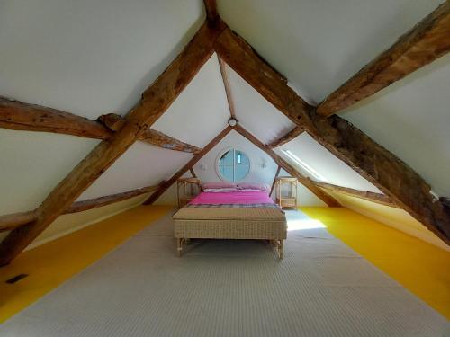 a room with a bed in a attic at Gesail Barn and Farmhouse in Machynlleth