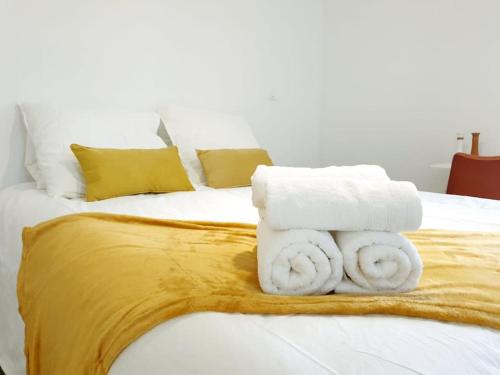 un lit avec des serviettes blanches dessus dans l'établissement Le Bohème, à Pamiers