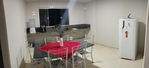 a small kitchen with a table and a refrigerator at Residencial Casa Grande Apto 04 in Santa Cruz Cabrália