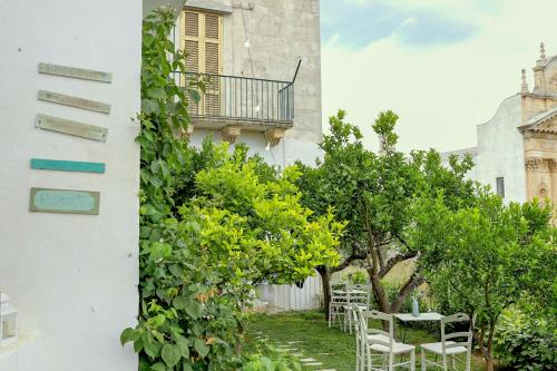 a garden with chairs and trees next to a building at Casa Agrumeto 28 in Ostuni