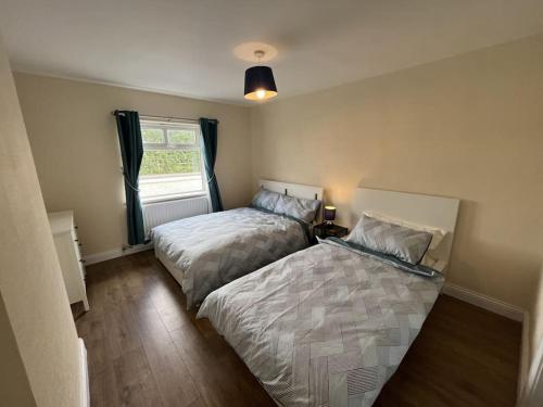 1 Schlafzimmer mit 2 Betten und einem Fenster in der Unterkunft The Moorlands in Dundalk