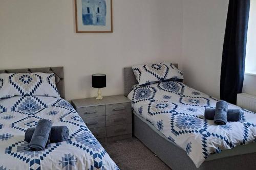 a bedroom with two twin beds and a night stand at Coolams in Ingleton