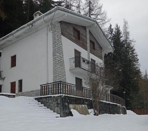 a large white building with a balcony in the snow at Maison Loren Pila in Cerise