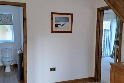 a bathroom with a toilet and a picture on the wall at Coolams in Ingleton