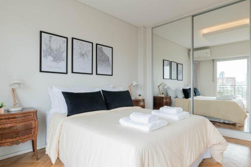 1 dormitorio con 1 cama blanca y 2 toallas en Las Heras 2700 - Luxury 3 Bd Palermo Chico en Buenos Aires