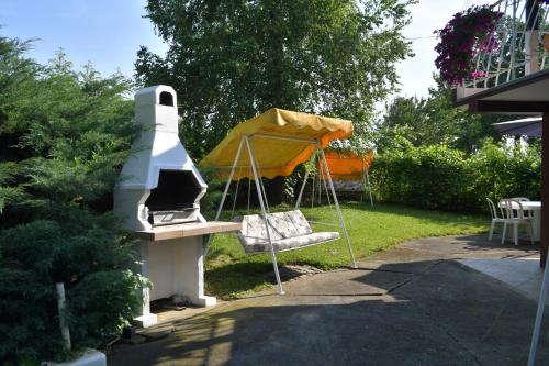 un barbecue in un cortile con una casa di Danube River house a Novi Sad