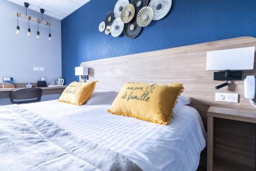 a bedroom with a large bed with a yellow pillow at Hôtel De La Plage in Le Chambon-sur-Lignon