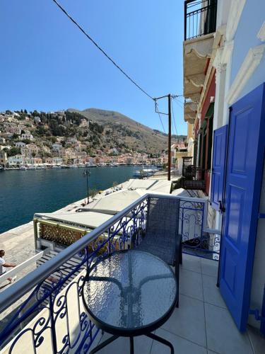 einen Balkon mit einem Tisch und Stühlen auf einem Gebäude in der Unterkunft Cavo apartment in Symi