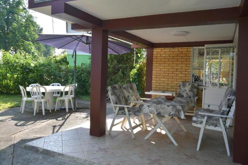 patio con tavolo, sedie e ombrellone di Danube River house a Novi Sad