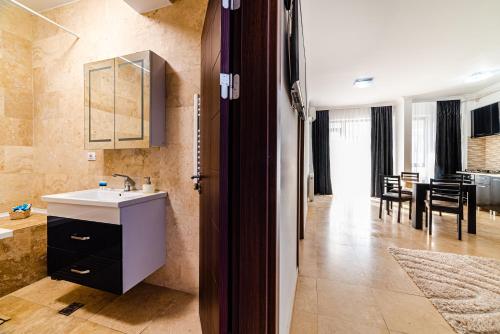 cocina y sala de estar con fregadero y mesa en Solid Residence Mamaia Luminita, en Mamaia