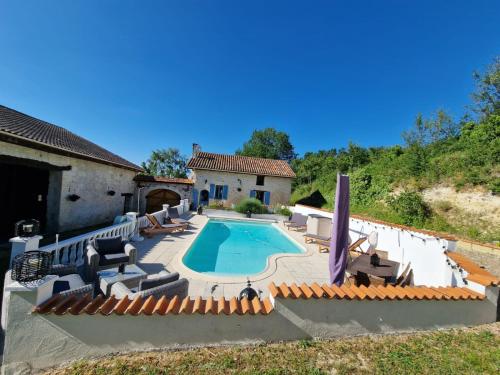 einen Pool mit Stühlen und ein Haus in der Unterkunft Maison de vacances in Vanxains