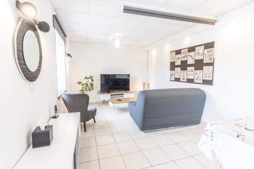 a living room with a couch and a tv at Hôtel De La Plage in Le Chambon-sur-Lignon