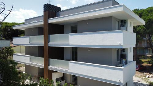 Bild eines Gebäudes mit weißen Balkonen in der Unterkunft Ca' Del Mare in Rosolina Mare