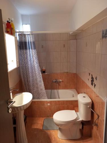 a bathroom with a toilet and a sink and a tub at City Nikis Apartment in Volos