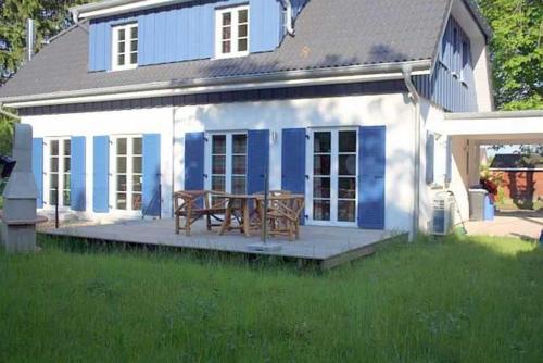 a blue and white house with a picnic table at Ruegen_Fewo 292 in Ummanz