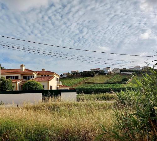 a house on top of a hill with a cloudy sky at Casa da Pedra Guest House in Torres Vedras