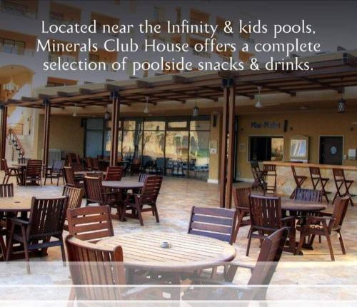 a restaurant with tables and chairs in a building at Dead Sea Jordan Sea View Samarah Resort Traveler Award 2024 winner in Sowayma