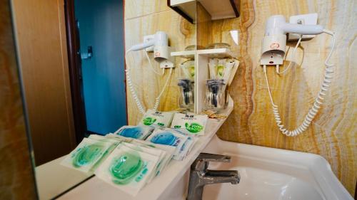 a bathroom with a sink and toothbrushes at HUAQIAO HOME 侨之家免费供早餐free breakfast served in Semporna