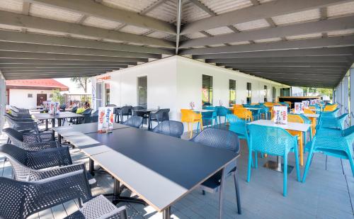 an outdoor patio with blue tables and chairs at Tisza-tó Apartmanpark in Kisköre