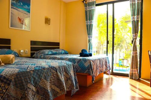 a bedroom with two beds and a teddy bear on a table at Hotel Rivera Del Mar in Puerto Escondido