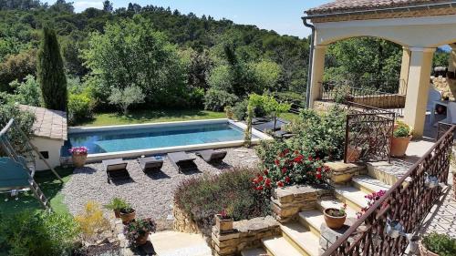 une maison avec une piscine dans une cour dans l'établissement Piscine chauffée au calme sur un domaine viticole familial grande maison climatisation, à Mondragon