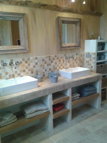 une salle de bain avec deux lavabos et deux miroirs dans l'établissement Piscine chauffée au calme sur un domaine viticole familial grande maison climatisation, à Mondragon