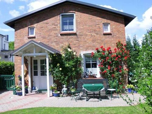 een stenen huis met een tafel en stoelen in de tuin bij Ruegen_Fewo 241 in Putbus