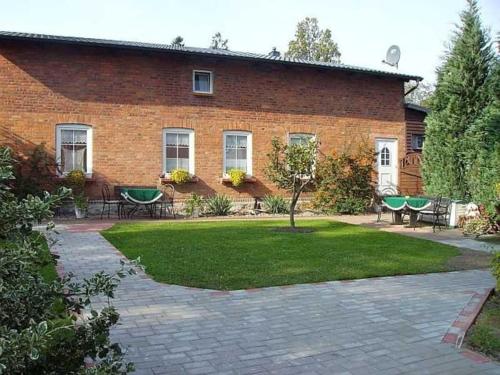 a brick building with a yard with tables and chairs at Ruegen_Fewo 241 in Putbus
