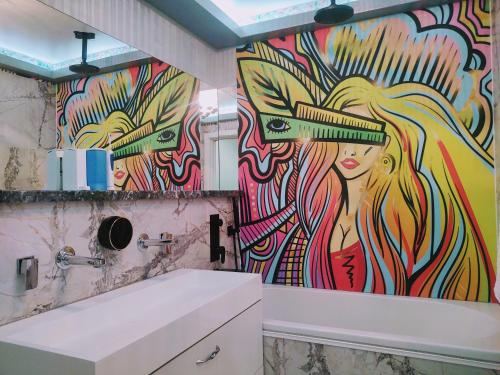 a bathroom with a mural of a woman on the wall at CezAri ApartHotel in Braşov