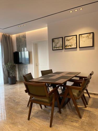 Olivea Apartments في فيليبوجي: غرفة طعام مع طاولة وكراسي خشبية