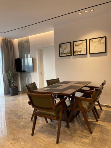 Un comedor con mesa y sillas de madera. en Olivea Apartments, en Velipojë