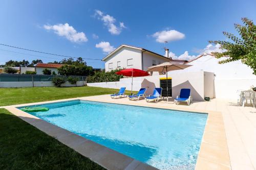 a swimming pool with chairs and a house at Casa do Azal in Ponte de Lima