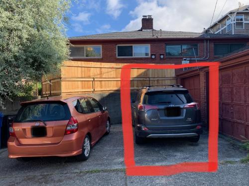 dois carros estacionados num parque de estacionamento em frente a uma casa em Best location in Charming Downtown Ballard! Rare Find! em Seattle