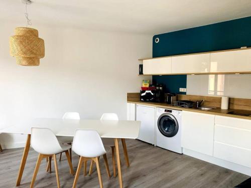 - une cuisine avec une table blanche et des chaises blanches dans l'établissement Magnifique appartement t2, à Collobrières