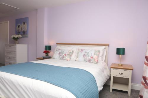 a bedroom with a bed with a blue blanket and pillows at Killala 3 bed house in Killala