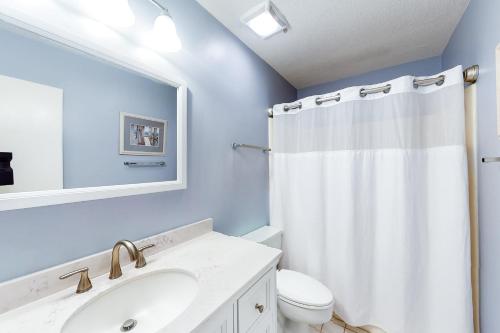 a bathroom with a white shower curtain and a sink at Ketch Court 893 in Hilton Head Island