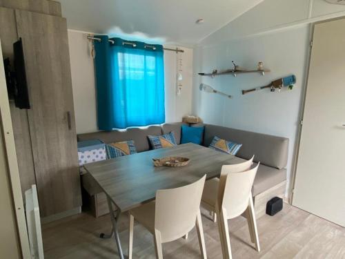 una mesa de comedor y sillas en una habitación en MH148 camping TOHAPI NOVELA - Mobil home 6p climatisé -, en Port-la-Nouvelle