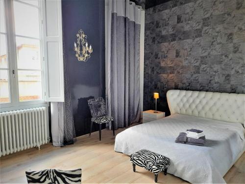 a bedroom with a white bed with a zebra pillow on it at PIED A TERRE DE CHARME in Albi