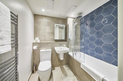 a bathroom with a toilet and a sink at Elegant Plus Luxury Apartments in London