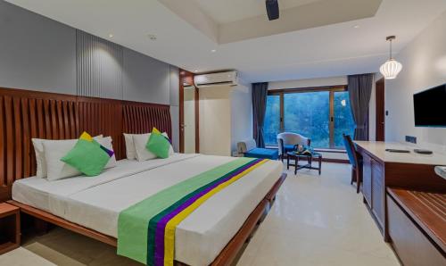 a hotel room with a large bed and a desk at Treebo Regency - Bund Garden, Dhole Patil Road in Pune