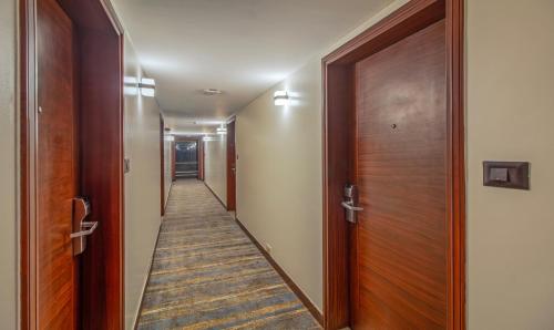 a hallway with wooden doors and a long corridor at Treebo Regency - Bund Garden, Dhole Patil Road in Pune